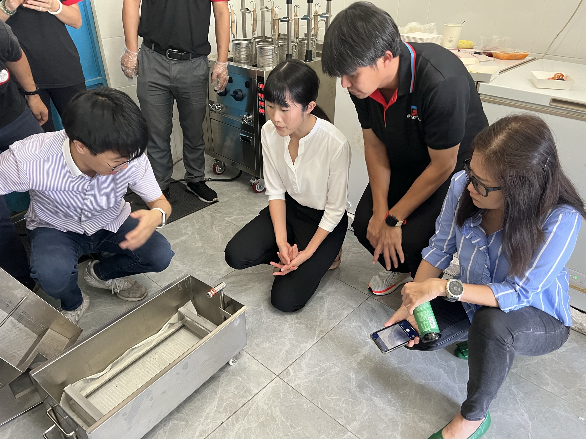 Harvey explaining the electric fryer oil filtration system to Goodwill Distributor from Thailand