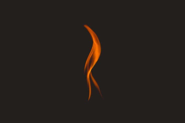 a single, elegant flame dancing against a dark, black background